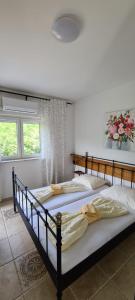 two beds in a bedroom with two windows at Bed & Breakfast BARBARA in Novi Vinodolski +15 photos