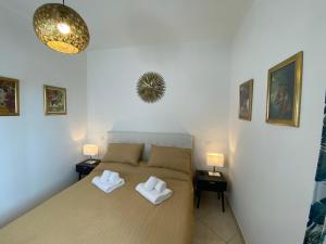 una camera da letto con un letto con due asciugamani bianchi di Caserta Royale Family a Coccagna