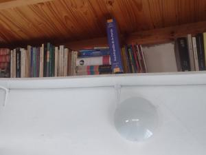 a shelf with books on it with a computer mouse at Espacio de arte físico in Buenos Aires