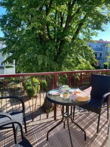 a table and chairs on a balcony with a tree at Residenz-Ostseewind-Wohnung-17-255 in Kühlungsborn