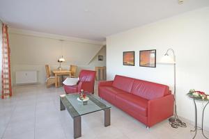 キュールングスボルンにあるHaus-Miramare-Wohnung-33-315のリビングルーム(赤いソファ、テーブル付)