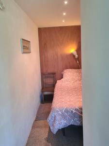 a small bedroom with a bed and a lamp at Bed & Breakfast 28 Appartement met Privé Tuin in Assen