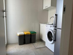 a laundry room with a washing machine and two trash cans at Villa Antonia sul mare con piscina Torre a mare (Bari) in Bari