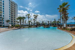 a large swimming pool with palm trees and a bridge at Palms of Destin by Panhandle Getaways in Destin