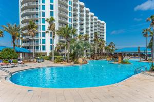 a swimming pool in front of a large apartment building at Palms of Destin by Panhandle Getaways in Destin