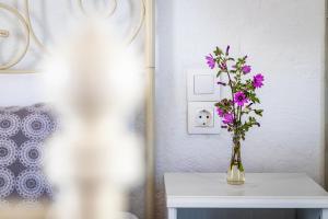 eine Vase mit lila Blumen auf einem Tisch in der Unterkunft Vainas Belvedere Villa in Skopelos