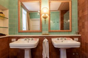 two sinks in a bathroom with two mirrors at FORESTERIA di PALAZZO RADICI in Bergamo