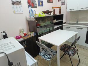 eine Küche mit einem weißen Tisch, Stühlen und einem Waschbecken in der Unterkunft b&b del corso in Iglesias