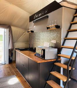 a kitchen in a tent with a counter and a microwave at Baladome in Dörgicse