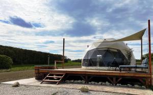 a tent on top of a wooden deck with a bench at Baladome in Dörgicse