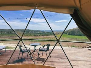 a view from a tent with chairs and a table at Baladome in Dörgicse