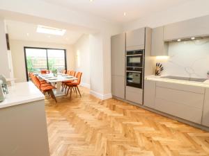 a kitchen and dining room with a wooden floor at Hillside House in Leyburn