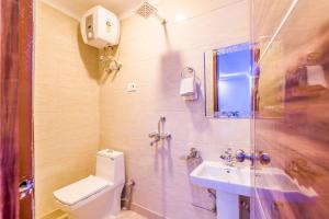 een badkamer met een toilet, een wastafel en een douche bij Hotel Festival Mahipalpur At Delhi Airport in New Delhi