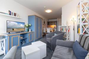 キュールングスボルンにあるYachthafenresidenz-Wohnung-5203-812のリビングルーム(青い家具、テレビ付)