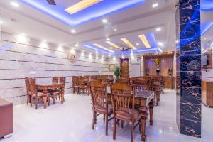 a dining room with wooden tables and chairs at Hotel Festival Mahipalpur At Delhi Airport in New Delhi