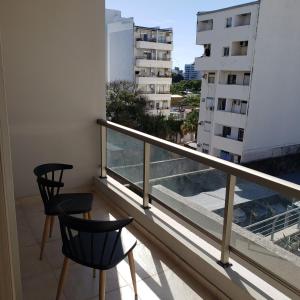 balcón con 2 sillas y vistas a un edificio en Departamento ALCLA I en Corrientes