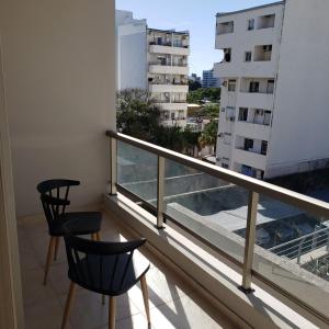 a balcony with two chairs and a view of a building at Dpto en Costanera, excelente ubicación in Corrientes