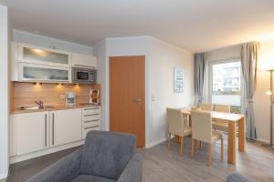 een keuken en eetkamer met een tafel en stoelen bij Yachthafenresidenz-Wohnung-6101-818 in Kühlungsborn