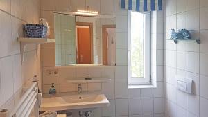 キュールングスボルンにあるYachthafenresidenz-Wohnung-8309-820のバスルーム(洗面台、鏡、窓付)