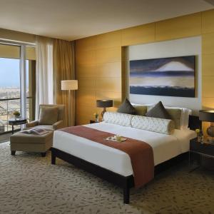 Suitestay Address Dubai Mall Residence في دبي: غرفة فندقية بسرير كبير وكرسي