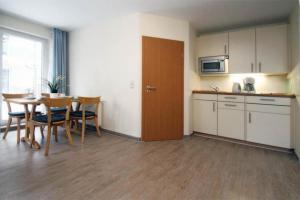 キュールングスボルンにあるYachthafenresidenz-Wohnung-6106-824のキッチン、テーブル、椅子が備わる客室です。