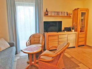 a living room with a tv and two chairs and a table at Yachthafenresidenz-Wohnung-6106-824 in Kühlungsborn
