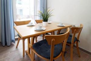 a dining room table with chairs and a wooden table at Yachthafenresidenz-Wohnung-6106-824 in Kühlungsborn