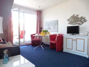 a living room with red chairs and a tv at Yachthafenresidenz - Wohnung 6302 / 835 in Kühlungsborn