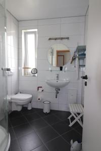a white bathroom with a sink and a toilet at Yachthafenresidenz - Wohnung 6302 / 835 in Kühlungsborn