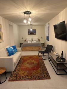 uma sala de estar com uma cama e um sofá em Porphyra Studio em Halki