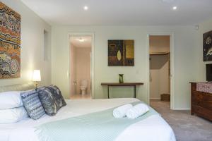 ein Schlafzimmer mit einem weißen Bett mit Handtüchern darauf in der Unterkunft Luxury resort style villa pool by Custom Bnb Hosting in Pelican Waters + 62 Fotos