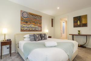 a bedroom with a large bed and a painting on the wall at Luxury resort style villa pool by Custom Bnb Hosting in Pelican Waters