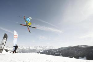 un hombre volando por el aire mientras montaba esquís en Ferienwohnung Stöckl, en Leogang