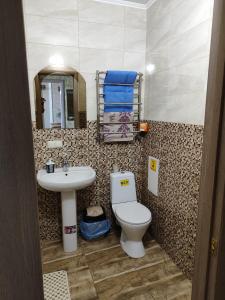 a bathroom with a toilet and a sink at Апартаменти в новому будинку біля Либідь Плаза-Квартал in Khmelʼnytsʼkyy