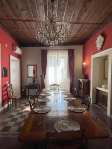 a dining room with a long table and a chandelier at Palazzo Toraldo di Francia in Tropea
