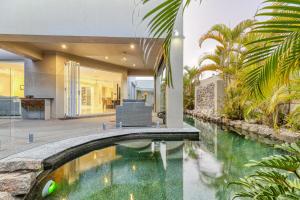 una vista exterior de una casa con piscina en Luxury resort style villa pool by Custom Bnb Hosting, en Pelican Waters