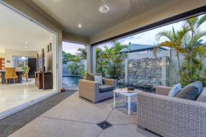 ein Wohnzimmer mit Glasschiebetüren und einer Terrasse in der Unterkunft Luxury resort style villa pool by Custom Bnb Hosting in Pelican Waters