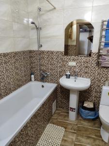 bagno con vasca, lavandino e servizi igienici di Апартаменти в новому будинку в самому центрi a Chmel'nyc'kyj