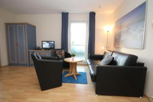 キュールングスボルンにあるYachthafenresidenz-Wohnung-7201-838のリビングルーム(黒革の家具、テーブル付)