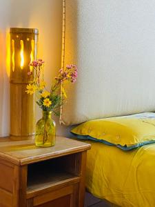 un jarrón de flores en una mesa junto a una cama en Al Volo B&B, en San Giovanni Teatino
