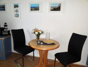 uma mesa com duas cadeiras e um vaso de flores sobre ela em Yachthafenresidenz-Wohnung-8109-847 em Kühlungsborn
