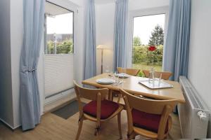 comedor con mesa, sillas y ventanas en Yachthafenresidenz-Wohnung-8110-848, en Kühlungsborn