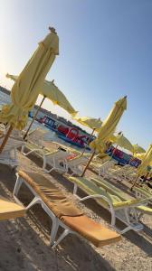 Delta في جدة: مجموعة من كراسي الحديقة والمظلات على الشاطئ