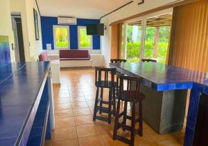 een keuken met een bar met krukken en een woonkamer bij Las Veraneras Villas & Resort in Acajutla