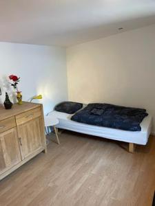 a bedroom with a bed and a wooden dresser at Rundvejen Guest House in Aalborg