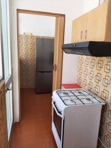 a kitchen with a stove and a door into a room at Casa Vacanza 30 in Galatina