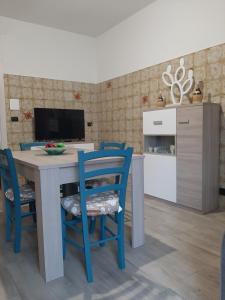 a kitchen with a table and blue chairs at Casa Vacanza 30 in Galatina