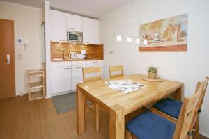 キュールングスボルンにあるYachthafenresidenz-Wohnung-8308-863のキッチン、ダイニングルーム(木製のテーブルと椅子付)