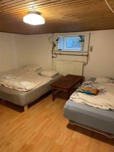 a room with two beds and a table and a window at Rundvejen Guest House in Aalborg