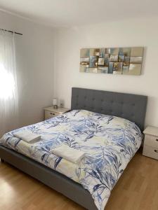 - une chambre avec un lit et une couette bleue et blanche dans l'établissement Holiday house Ana, à Skradin
